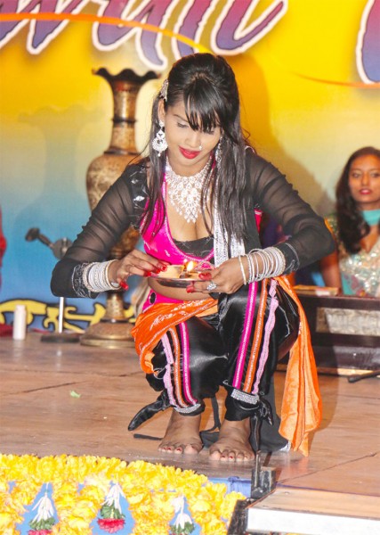 A member of the Ishara Dance Troupe lights a diya during a performance at GT&T’s “Diwali Galee” last night, which saw the symbolic lighting of trees at the corners of Camp and Church streets to usher in the festival of lights. (Photo by Arian Browne)