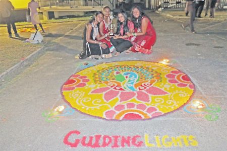 Rangoli winner: Final year Economics students from the University of Guyana posing with their winning Rangoli design last evening. Each year, to coincide with the festival of Diwali, the university organizes a Rangoli competition where designs are made with coloured rice. (Arian Browne photo)