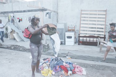 A resident going through Dennis Caldeira’s clothes on the road.