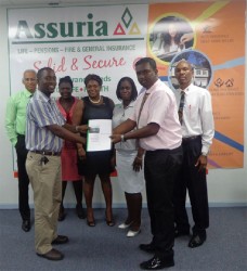  Assuria General Manager (Ag) Yogindra Arjune (second from right) presents a copy of the Guyana Teachers Union (GTU) agreement to GTU president Mark Lyte while representatives from both entities: Clyde Muntslag, Coretta McDonald, Eulalie Wilson, Lesmeine Collins and Erwin Daniels look on. 