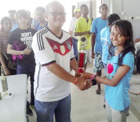 Sheriffa Ali receives her trophy after winning the blitz chess tournament in Suriname. 