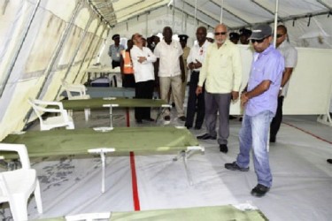 President Donald Ramotar accompanied by Health Minister Dr. Bheri Ramsaran and Public Works Minister Robeson Benn,  visiting one of the medical tents set up at the Cheddi Jagan International Airport, Timehri. (GINA photo)  