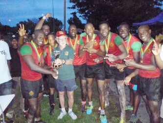Patron of the GRFU, Kit Nascimento presenting the champion’s trophy to the GDF players. 