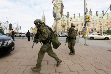 Armed RCMP officers head towards the Langevin Block on Parliament Hill following a shooting incident in Ottawa October 22, 2014.
REUTERS/Chris Wattie
