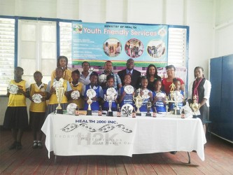 Members of some of the participating schools displaying the footballs received from the Petra Organization while Chief Education Officer Olatto Sam (standing centre), Petra Organization Co-Director Troy Mendonca (standing third from left), Ansa McAl Pro Darshanie Yusuf (standing fifth from left) and other members of the Ministry of Health, Ministry of Education and Heath 2000 Guyana Inc. look on 