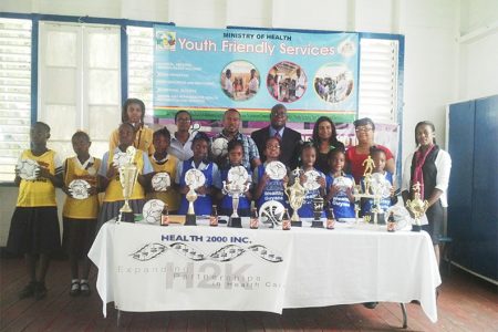 Members of some of the participating schools displaying the footballs received from the Petra Organization while Chief Education Officer Olatto Sam (standing centre), Petra Organization Co-Director Troy Mendonca (standing third from left), Ansa McAl Pro Darshanie Yusuf (standing fifth from left) and other members of the Ministry of Health, Ministry of Education and Heath 2000 Guyana Inc. look on