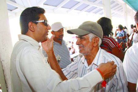 Hello again: Attorney General, Anil Nandlall (left) is pleasantly surprised to see his old Common Entrance teacher, Reo Chanali. The occasion was the distribution yesterday of the $10,000 education vouchers on the East Coast of Demerara at the Annandale Secondary School. In recent weeks Nandlall has been buffeted by calls for his resignation over statements made in a phone conversation which was taped and subsequently released. (GINA photo)
