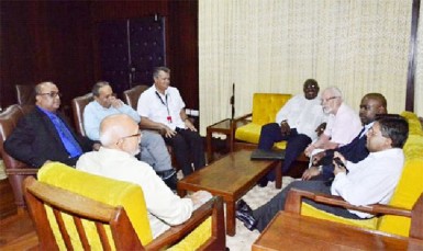 President Donald Ramotar (back to camera) and Finance Minister, Dr. Ashni Singh (right) meeting  executives of the Private Sector Commission (GINA photo) 