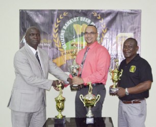 Phillip Jaiserrisingh, centre, Credit and marketing manager of Citizens Banks Guyana Limited, presents the trophies at stake in today’s foursome golf tournament to PRO of the Lusignan Golf Clun Buy Griffith in the presence of Banks DIH Limited Communications Manager Troy Peters. 
