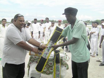 GCB President, Drubahadur handing over a cricket bat to Mortimer Denny. 