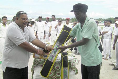 GCB President, Drubahadur handing over a cricket bat to Mortimer Denny.