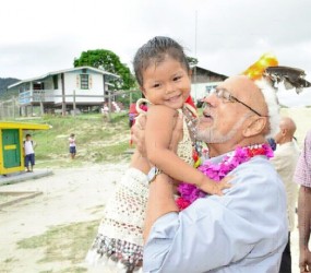 President Donald Ramotar saying hello to a young Paramakatoi resident who garlanded him on his arrival (GINA photo) 