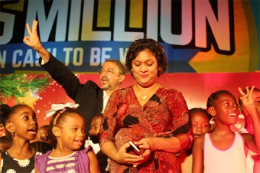 Minister of Education Priya Manickchand gets set to light the trees as several children assist Managing Director of Courts Clyde de Haas (behind Manickchand) with the countdown. (Photo by Rae Wiltshire) 