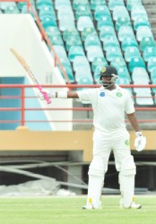 Narsingh Deonarine calmly raises his bat to acknowledge a well-played half-century  