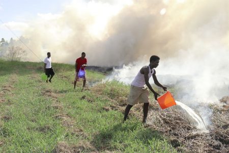 UGSS President Joshua Griffith (forefront) and other UG students aided in yesterday’s efforts to contain a wildfire that occurred on the university’s Turkeyen campus
