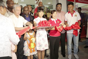 China’s Ambassador Zhang Limin (extreme left) and Lilian Wang (second right), cut the ribbon yesterday afternoon to open the building. Jason Wang (extreme right) stands beside his wife Lilian. 