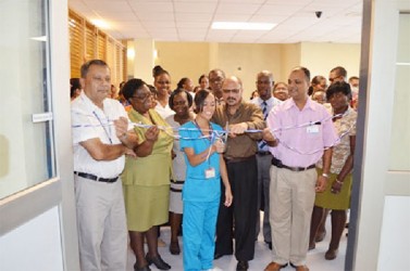 Minister of Health Dr Bheri Ramsaran (second from right in front row) along with Georgetown Public Hospital Corporation’s Chief Executive Officer (CEO)  Michael Khan (left) among staff of the facility cutting the ribbon to commission the unit
