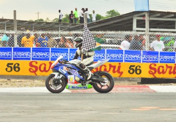 Nikhil Seeraram celebrating with the checkered flag yesterday. (Orlando Charles photo) 