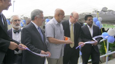 President Donald Ramotar (third from right), assisted by Vice Chairman and Executive Vice President, Unicomer Guyana Group Guillermo Siman and others, cuts the ribbon to officially open the facility. 