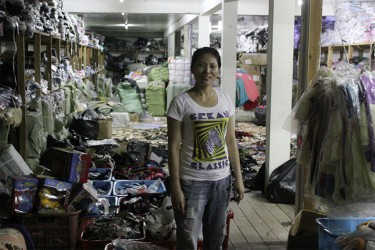 A Chinese store employee with store goods that were damaged by the flooding.  