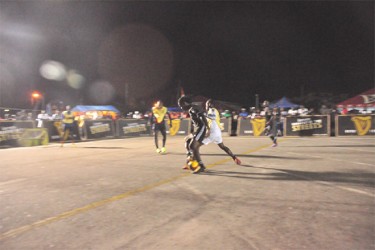 North Ruimveldt’s Gerald Gittens (black/centre) battling to maintain possession of the ball against his West Back Road marker during his team’s upset loss  