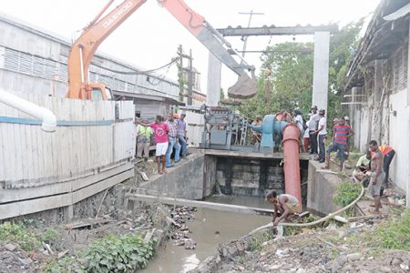 Workers yesterday attempted to remedy a breach in the Sussex Street koker which quickly flooded the Albouystown community
