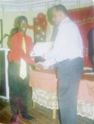 Shaquille Grant collecting his certificate from Home Affairs Minister Clement Rohee, after being registered as a member of the Community Policing Group