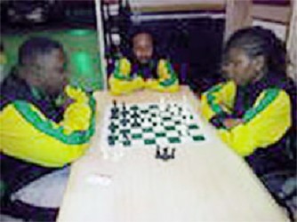 Appearing resplendent in their famous sports uniform is Jamaica’s chess contingent for the 2014 Umada Cup. National Master Andrew Mellace (2083) is concentrating deeply during a friendly game against Woman International Master Deborah Richards-Porter (2013) at the Regency Hotel on Hadfield St. At the centre of the photo taking an interest in the game is Candidate Master Ras Malaku Lorne (2084). The three Jamaican chess players arrived in Guyana on Wednesday for the celebrated Umada Cup which is being held locally for the first time. 