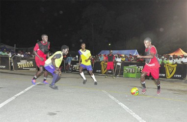 North Ruimveldt’s Travis Grant (right) in the process of initiating an attack with Deon Alfred (second right) and Jason Fredericks (third right) of Queen Street Tigerbay on the defensive 