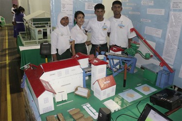 The students of the Abram Zuil Secondary School with their “Paddy Husk Particle Board” project, which was prompted by smoke and air pollution that affect residents of their community due to the burning of the rice husk. (Photo by Arian Browne)