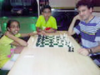 Two kids from Suriname, Alisha Jai Persaud, 11, and Ishvar Ramlal,12,  and a male chess player from Barbados, Fide Master Martyn Del Castillo pause from a warm-up encounter to allow a photo to be taken on Wednesday afternoon at the Regency Hotel. The trio is here to participate in the Umada Cup five-day tournament. Del Castillo had emerged victorious in the 2011 version of the Umada Cup.