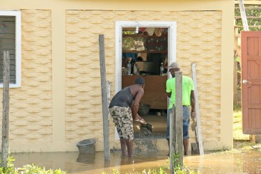 Preventative measures were being taken by these Buxton householders yesterday to thwart flooding as water built up in the yard.