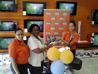 This Lucky Dollar photo shows Denise Benjamin (centre) receiving her prize