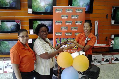 This Lucky Dollar photo shows Denise Benjamin (centre) receiving her prize