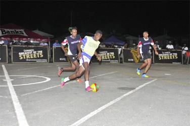 Leopold Street’s Okeene Fraser (centre/yellow vest) on the attack down the centre of the tarmac while being pursued by Festival City Street Fighter’s Odel Williams (left) 