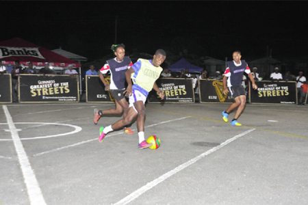 Leopold Street’s Okeene Fraser (centre/yellow vest) on the attack down the centre of the tarmac while being pursued by Festival City Street Fighter’s Odel Williams (left)
