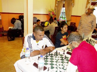 Former Guyanese national junior and senior chess champion Kriskal Persaud (left) is seen defeating Keith Simpson, a former GDF soldier, in the Umada Cup chess tournament. 