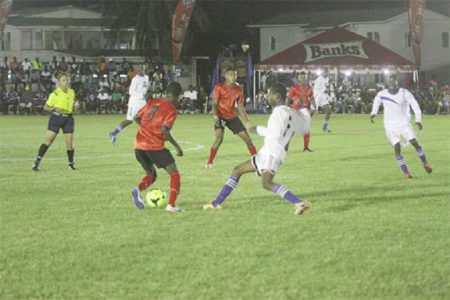 Alpha United’s Travis Grant (no.8) trying to maintain possession of the ball while being challenged by a Black Water player during the opening match of the GFA/Banks Beer Cup