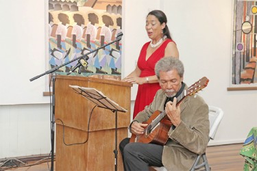 Ena Harvey sings while Stanley Greaves plays the guitar at the launch of his exhibition 