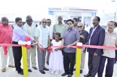 President Donald Ramotar (fourth from left), Minister of Finance, Dr Ashni Singh (fourth from right) and Minister of Public Works, Robeson Benn (third from left) at the ribbon cutting ceremony to commission GUYOIL’s Aviation Services Fuel Handling facility. (GINA photo)