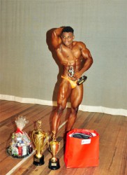 Mr. Flex Night 2014, Godfrey Stoby flexes with his spoils after posing his way to the overall honours. (Orlando Charles photo) 