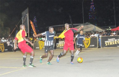 North Ruimveldt’s Joshua Browne (second from right) trying to keep possession of the ball while being challenged from Kevin Lewis (third from right) of Globe Yard during their quarterfinal showdown 