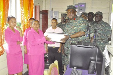 Chief of Staff Brigadier Mark Phillips (right) handing over the outboard engine. (GDF photo) 