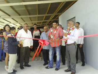 Minister of Tourism, Industry and Commerce, Irfaan Ali (second from right) and David Safeek( second from left) cut the ribbon as the Prime Minister, Samuel Hinds (front right) and other guests looks on.  