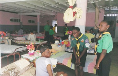 Two Scouts engage a resident of the Dharm Shala during the Share-a-Meal outreach at the Dharm Shala. 