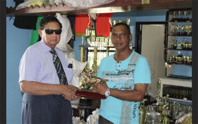 Former Chancellor of the Judiciary Cecil Kennard recieves from Trophy Stall’s Ramesh Sunich, the trophy for the most outstanding jockey at today’s meet.   