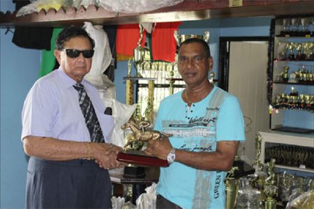 Former Chancellor of the Judiciary Cecil Kennard recieves from Trophy Stall’s Ramesh Sunich, the trophy for the most outstanding jockey at today’s meet.