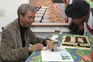 Stanley Greaves signing exhibition catalogues at the end of the birthday celebration in his  honour hosted by the National Gallery of Art at Castellani House (Photo by Arian Browne) 