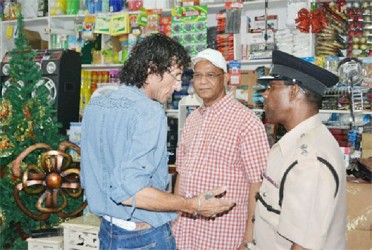 A store owner (left) speaking to ‘A’ Division Commander, Clifton Hicken as Minister of Home Affairs Clement Rohee looks on. (GINA photo)