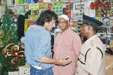 A store owner (left) speaking to ‘A’ Division Commander, Clifton Hicken as Minister of Home Affairs Clement Rohee looks on. (GINA photo)